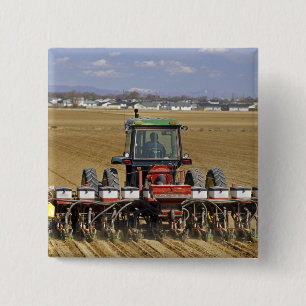 Tractor pulling a seed corn planter. pinback button