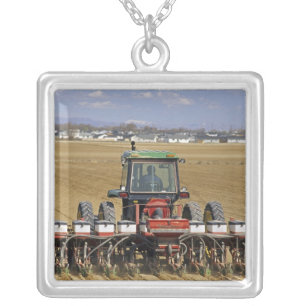 Tractor pulling a seed corn planter. silver plated necklace