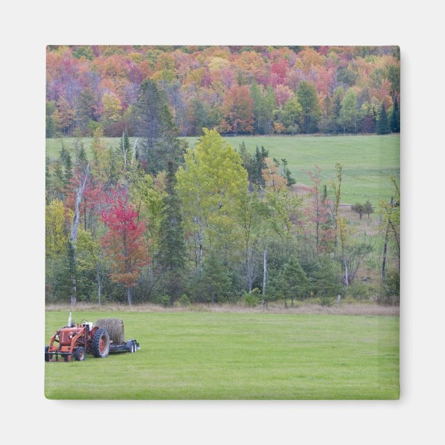 Tractor with hay bale in green field with magnet (Front)