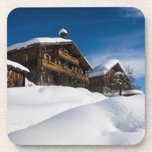 Traditional wooden cabins in de snow beverage coaster