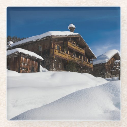 Traditional wooden cabins in de snow glass coaster