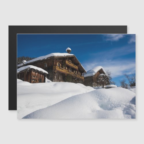 Traditional wooden cabins in de snow magnetic invitation