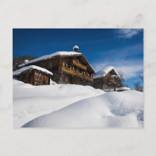 Traditional wooden cabins in de snow postcard
