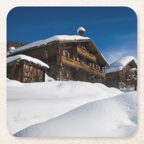 Traditional wooden cabins in de snow square paper coaster