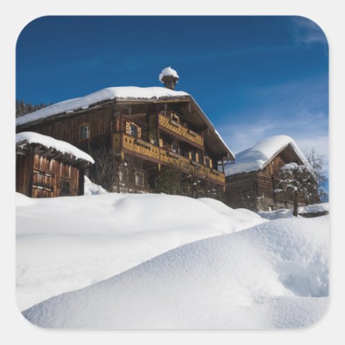 Traditional wooden cabins in de snow square sticker