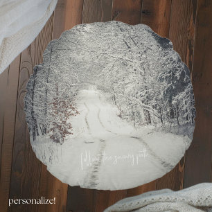 Trail through a snow-covered winter forest round pillow