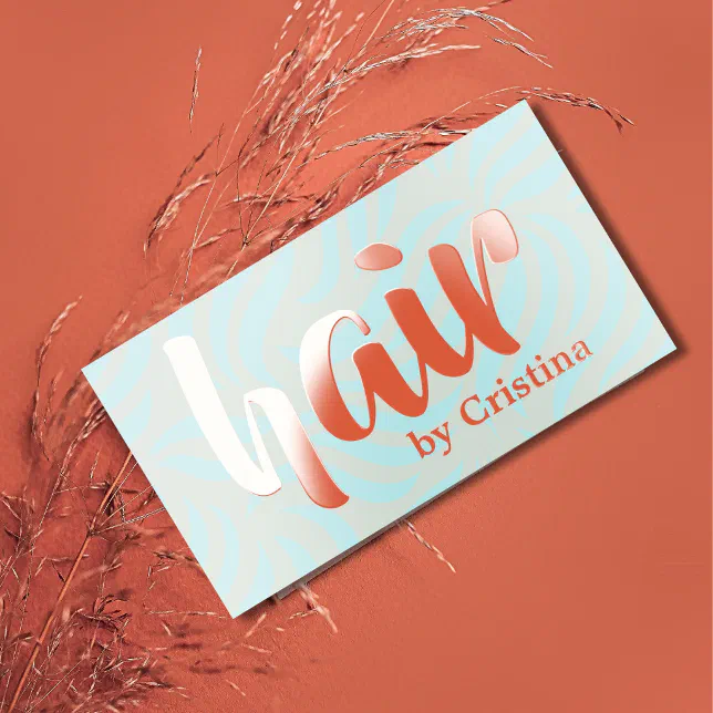 A blue and orange hair stylist's business card is shown against an orange background.