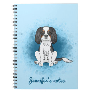 Tricolor Cavalier King Charles Spaniel Dog On Blue Notebook