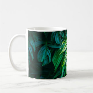 Tropical green leaves on dark background, nature s coffee mug