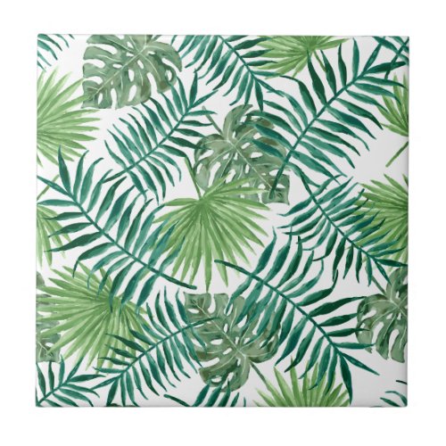 Tropical green leaves on white ceramic tile