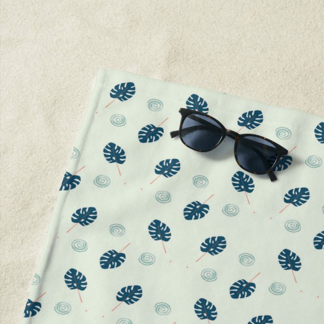 Tropical monstera leaves monogram on blue beach towel (In Situ)
