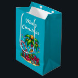 Tropical Palm Tree Merry Christmas Medium Gift Bag<br><div class="desc">Gift bag with a seasonal holiday image. A tropical palm tree decorated in festive lights with a star on top. A giant red and white candy cane sticking out of the sand. Christmas presents under the tree. Whimsical and fun.</div>