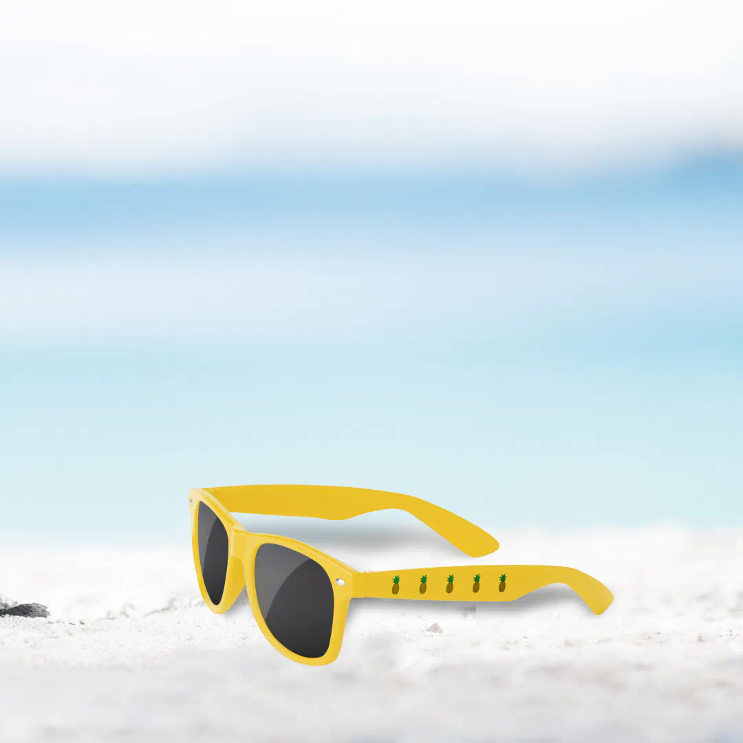 A blue and white faded background with yellow and black sunglasses in the middle. Small pineapples are printed on the handle of the glasses.