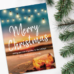 Tropical Sunset Beach Christmas Lights Holiday Card<br><div class="desc">Coastal destination christmas holiday cards featuring a sunset tropical beach,  a mason jar with sparkling fairy lights,  string twinkle lights,  the saying 'merry christmas',  a personal message,  and your name.</div>