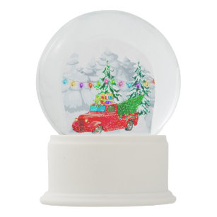 Truck carrying xmas tree gifts in winter snow snow globe