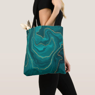 Turquoise liquid marble background with gold tote bag