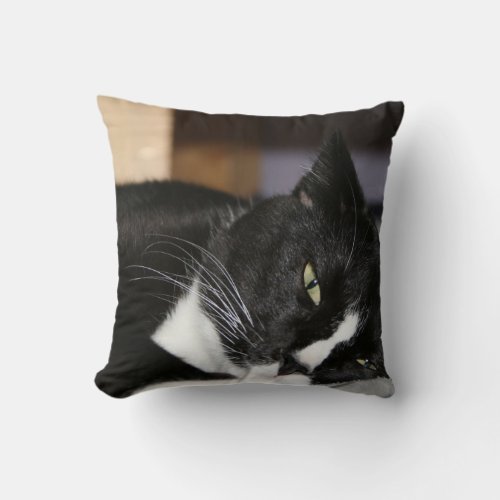 tuxedo cat black and white lying down one eye open throw pillow