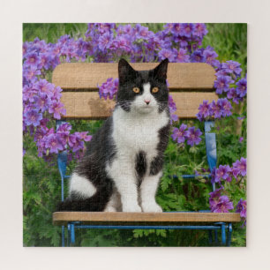 Tuxedo cat sitting on a garden chair with flowers jigsaw puzzle
