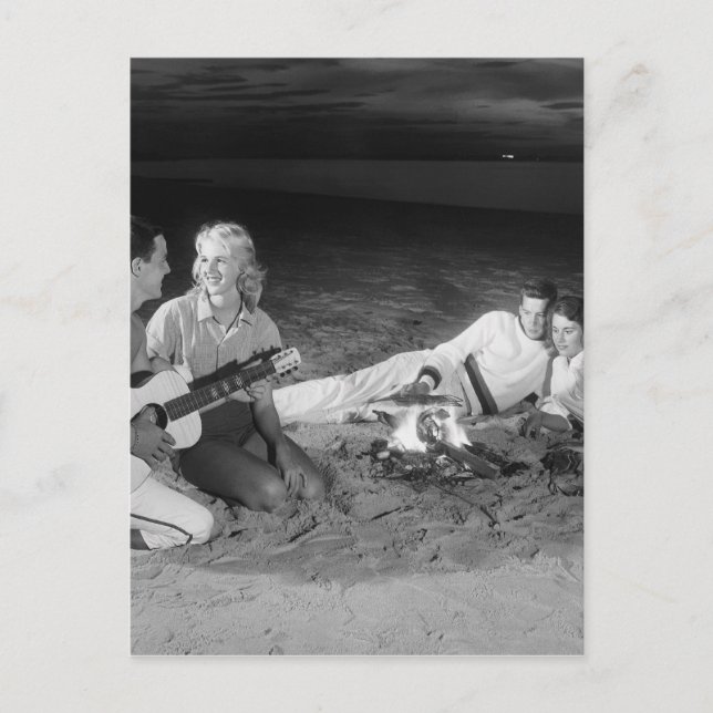 Two couples on beach sitting around campfire postcard (Front)