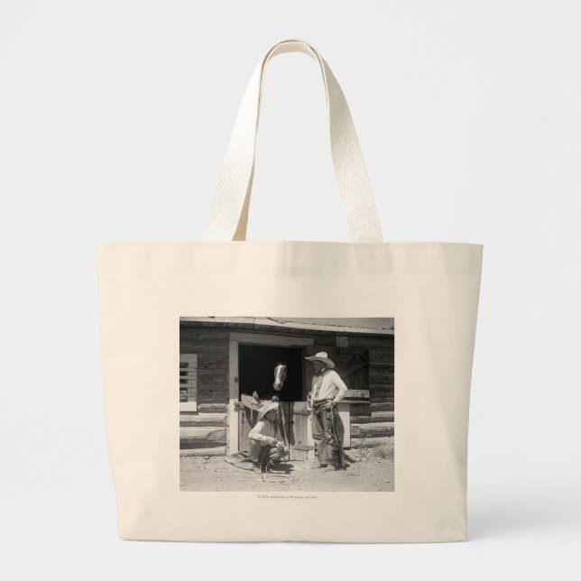 Two cowboys standing next to a barn with a horse large tote bag (Front)