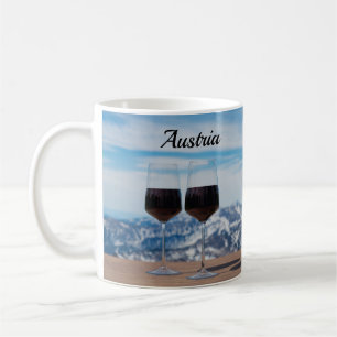 Two glasses of red wine against mountains coffee mug