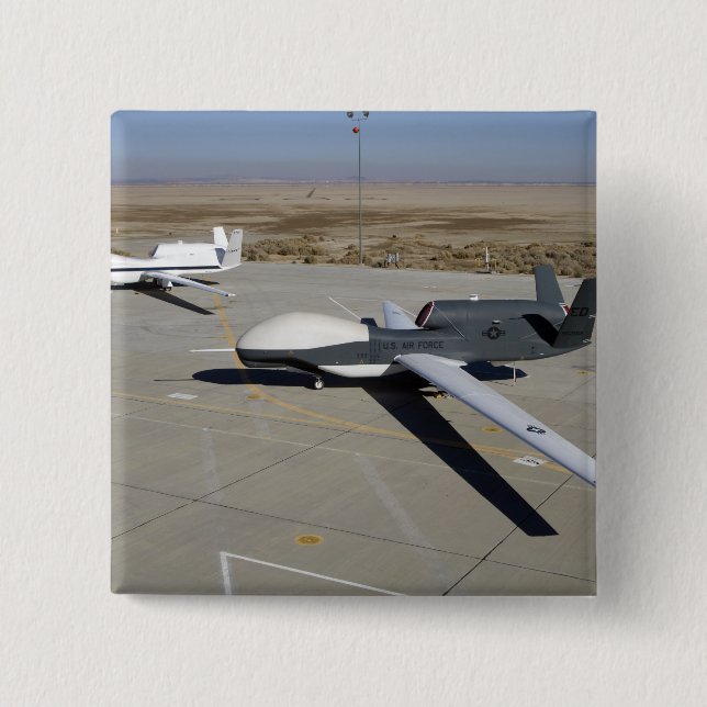 Two Global Hawks parked on a ramp Button (Front)
