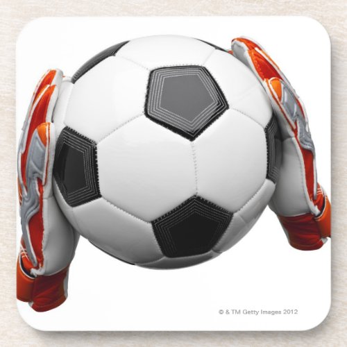 Two goal keepers gloves holding a football beverage coaster
