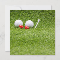 Two golf ball with two red hearts on green grass