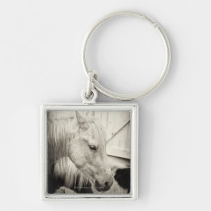 two horses outside a stable- black and white keychain