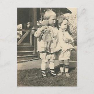 Two kids with a doll outside postcard