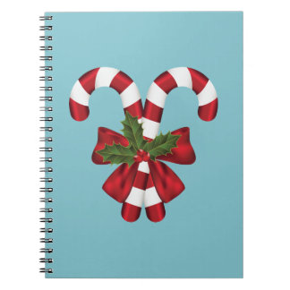 Two Red And White Festive Candy Canes On Blue Notebook
