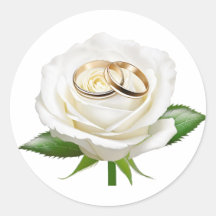 Two wedding rings on a white rose 