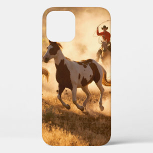 Two western cowboys riding horses, roping wild hor iPhone 12 case