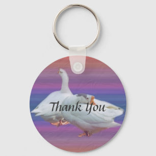 two white geese in fancy background. thank you keychain