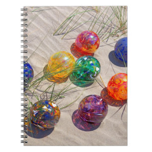 USA, Oregon. Colorful Glass Floats On Sand Dune Notebook