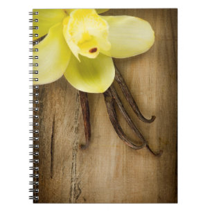 Vanilla Pods and Flower over Wooden Background Notebook