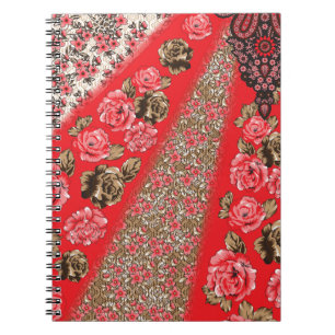 Vibrant red fabric featuring intricate floral and notebook