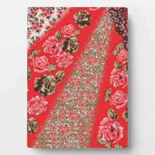 Vibrant red fabric featuring intricate floral and plaque