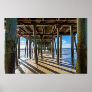View of the ocean from under the pier poster