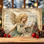 Vintage Angel Music Notes Christmas<br><div class="desc">Send a heavenly message this season with this vintage-inspired angel Christmas card. Featuring a beautiful angel reading music, framed by festive holly and a background of classic sheet music, this card brings an ethereal touch to your holiday greetings. Perfect for anyone who loves traditional holiday imagery with a spiritual theme....</div>