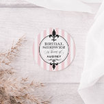Vintage Blush Pink French Bridal Shower Classic Round Sticker<br><div class="desc">Vintage chic French themed round wedding bridal shower stickers feature black decorative fleur de lis symbols,  ornate flourishes,  ballet / blush pink and white parlor stripes,  and elegant custom script text that can be personalized for the bride-to-be and her magnifique Parisian event.</div>