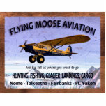 Vintage Flying Moose Aviation Sign Cutout<br><div class="desc">A weathered sign advertising the services of mythical Flying Moose Aviation of Talkeetna, Alaska. It features one of the company's blue-and-Yellow aircraft equipped with extra-large "tundra tires" for landing on rough terrain . Text reading, "FLYING MOOSE AVIATION", "We fly, tell us where you want to go", "HUNTING, FISHING, GLACIER LANDINGS,...</div>