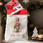 Vintage Nutcracker & Merry Christmas Tote Bag<br><div class="desc">A beautifully illustrated vintage-style Nutcracker soldier, resplendent in his classic attire, stands tall, holding a Merry Christmas banner. The rich, warm colors and intricate details evoke a sense of yuletide nostalgia, making it a perfect choice for those who appreciate the classic holiday aesthetics. May your holiday season be filled with...</div>