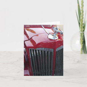 vintage red car chrome hood ornament on a card