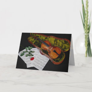Violin and red rose on black background card