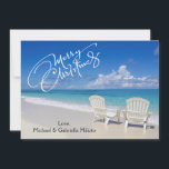Warm Sunny Beach With Chairs Christmas Card<br><div class="desc">Warm holiday wishes from the beach. In a white script is says, "Merry Christmas". There's a bright blue sky an ocean and beautiful sand. The ocean with crystal blue water is crashing along the sand. There's 2 white chairs by the water. Check out the many other beach scenes and products...</div>