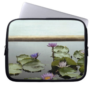 Water lilies in pond by ocean laptop sleeve