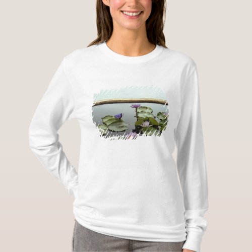 Water lilies in pond by ocean T_Shirt