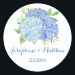Watercolor Blue Hydrangea Flowers Wedding Classic Round Sticker<br><div class="desc">These wedding stickers feature a watercolor design with blue hydrangeas and green foliage. Personalize them with your names and wedding date. These stickers are ideal for use as envelope seal stickers or for decorating wedding favors. These stickers are part of a collection which includes a range of matching wedding stationery....</div>
