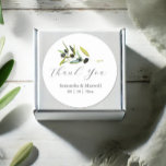 Watercolor Olive Branch Wedding Classic Round Sticker<br><div class="desc">Elevate your wedding favors with these elegant olive stickers, perfect for adding a touch of Italian charm to your special day. Featuring the words "Thank You" in trendy script typography, these stickers showcase a minimalist design adorned with a beautiful sprig of watercolor olive foliage. The botanical greenery offers a rustic...</div>